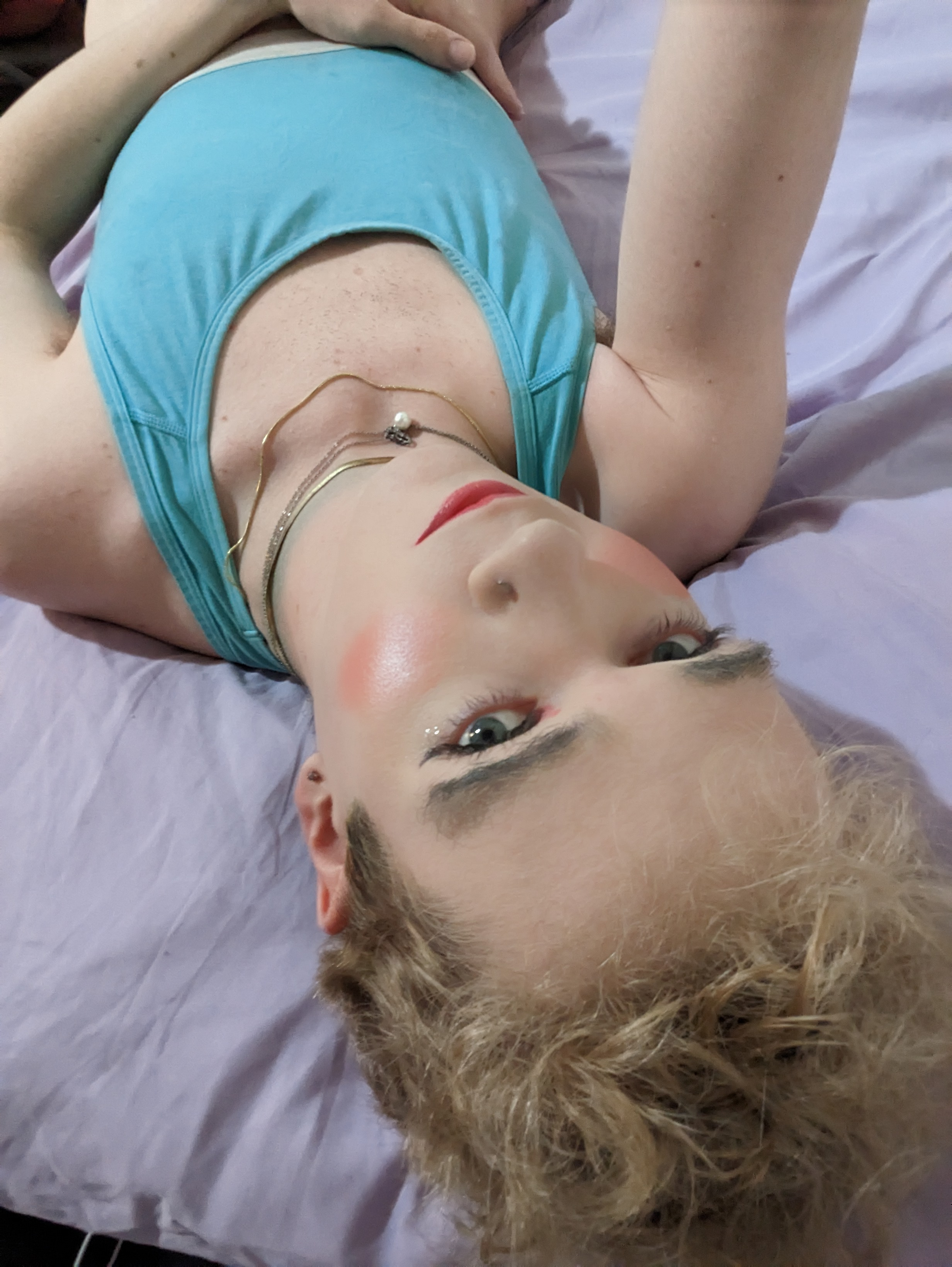 This photo shows a woman lying down on a light purple surface,... - by Daisy