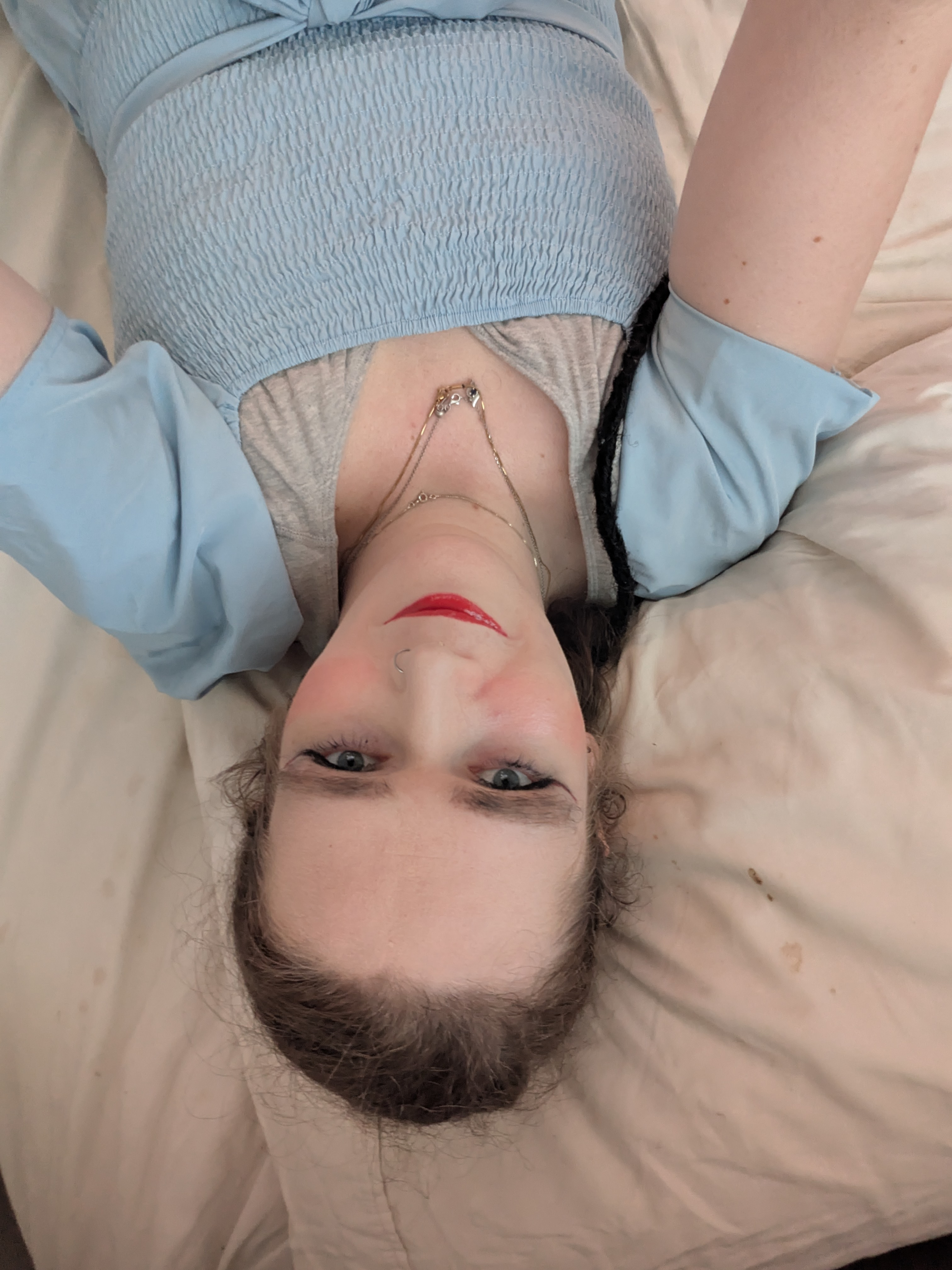'N Vrou wat met haar kop op 'n kussing op 'n bed lê.