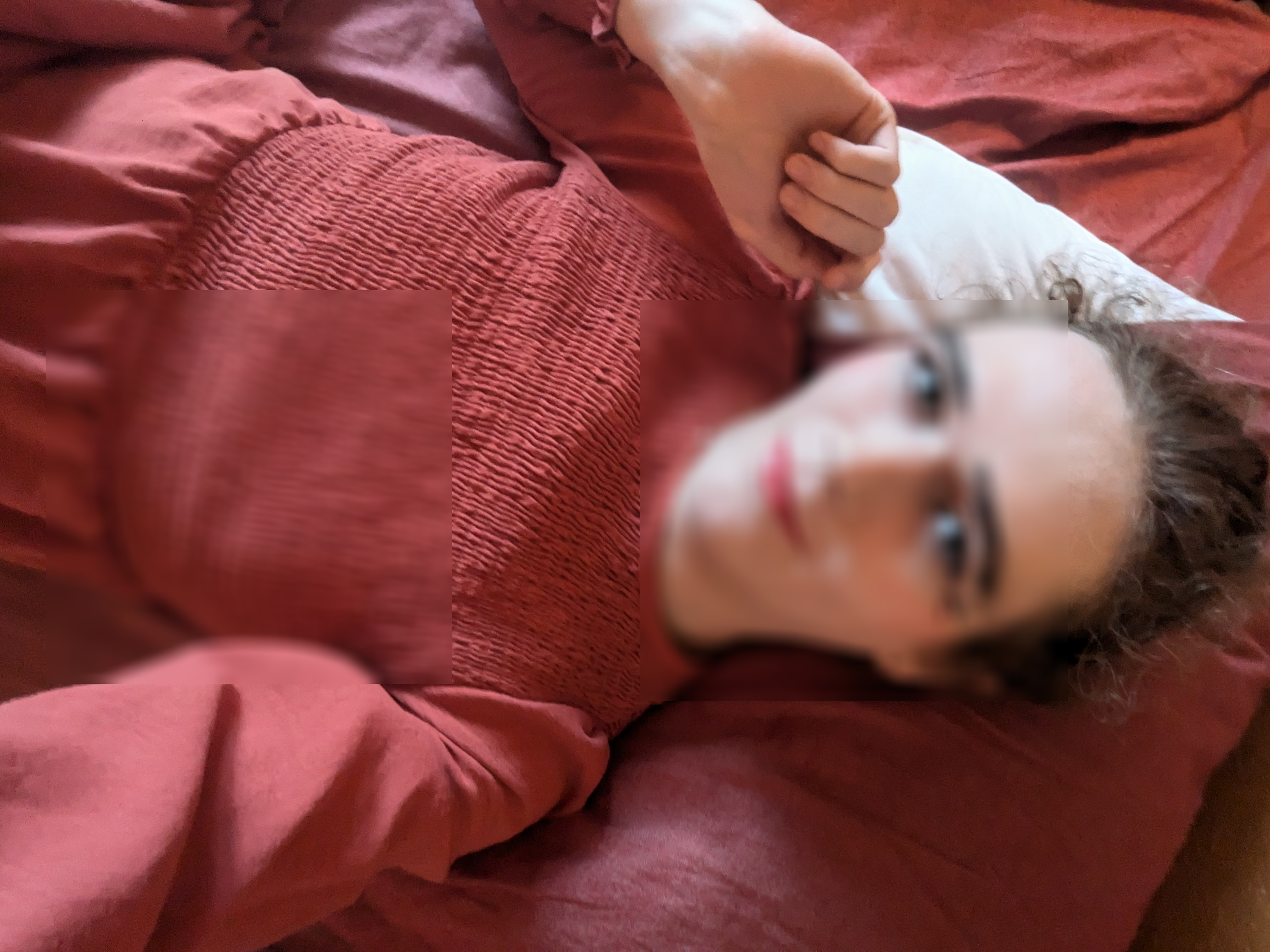 The photo shows a woman lying down on a red bed or couch, resting... - sa pamamagitan ng Daisy