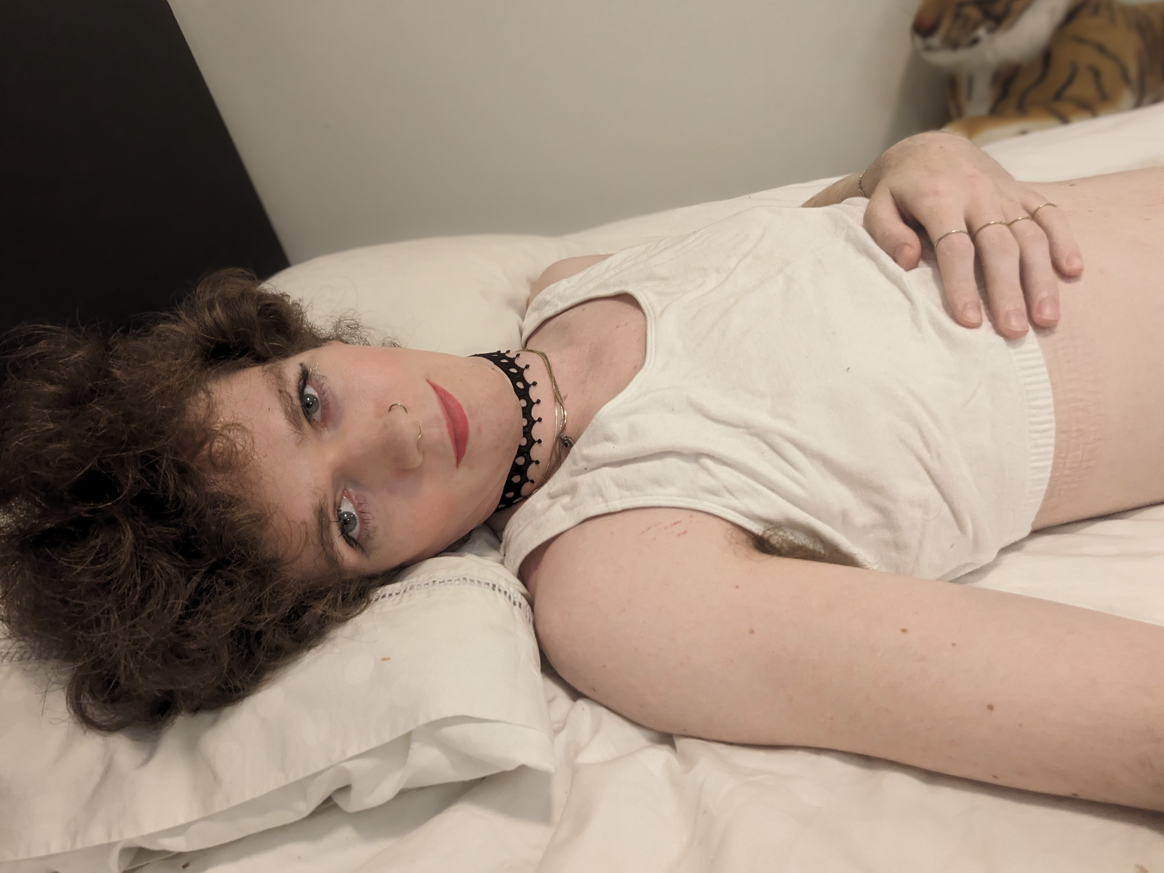 The photo features a woman lying on a bed, resting her head on a... - by Daisy