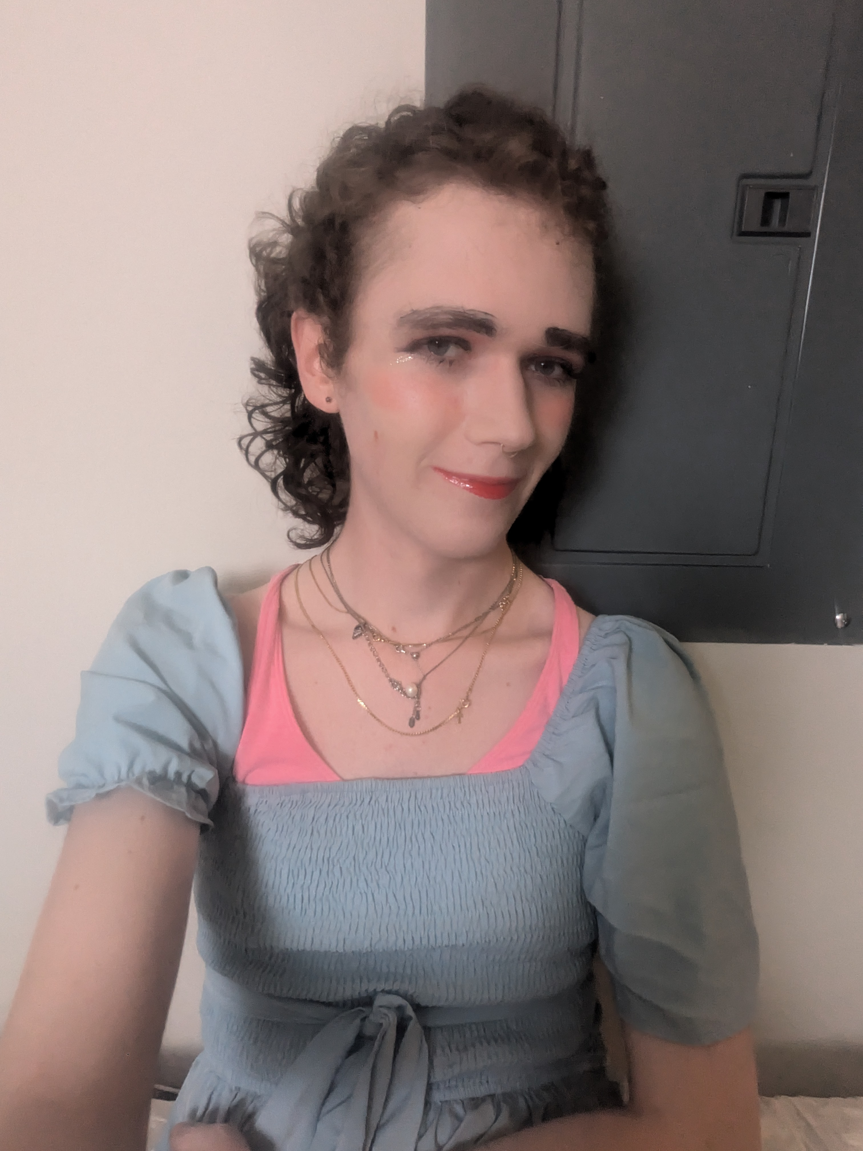 The photo shows a woman with curly hair, wearing makeup including... - by Daisy