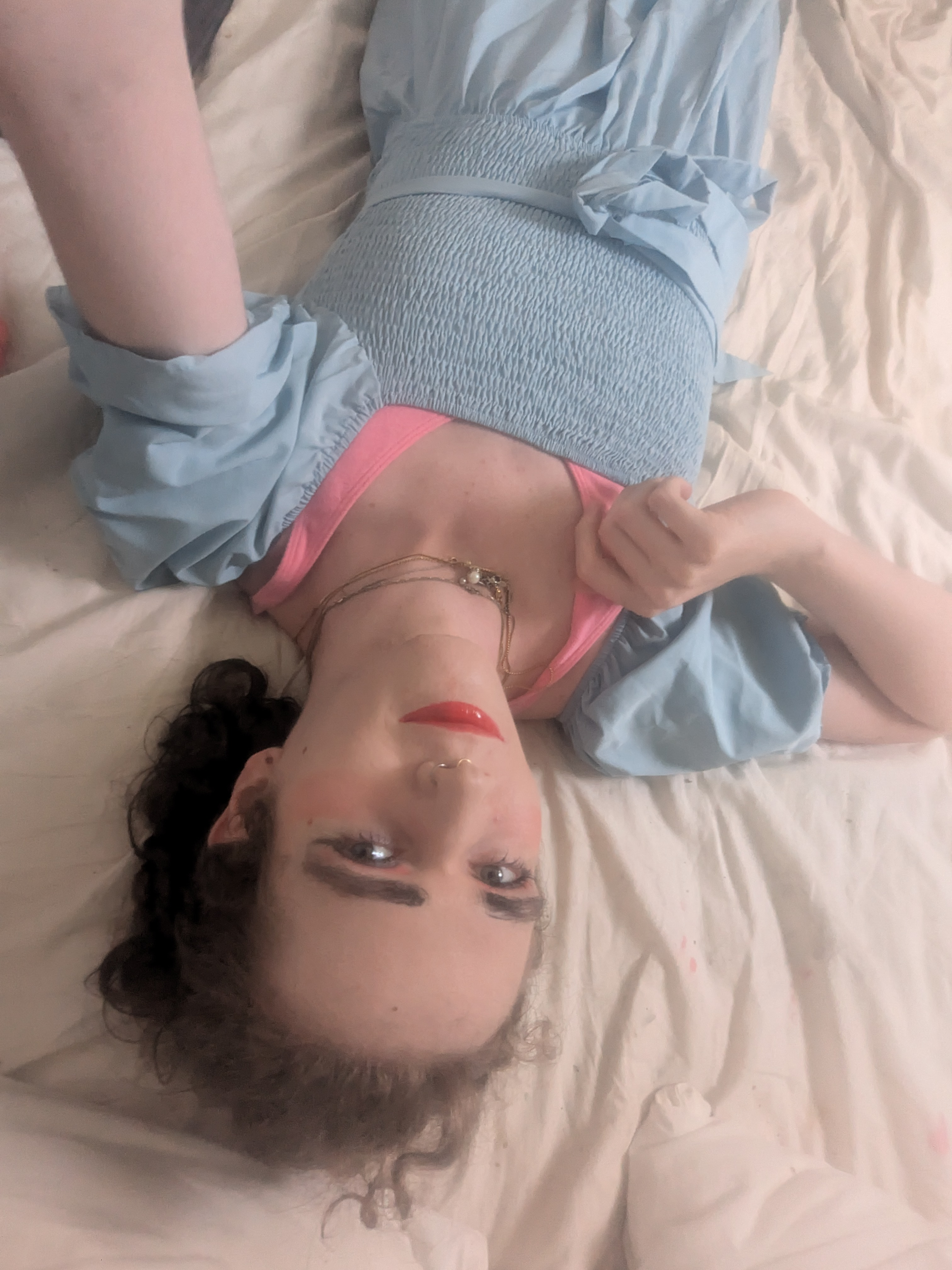 The photo shows a woman lying on a bed and taking a selfie. The... - by Daisy