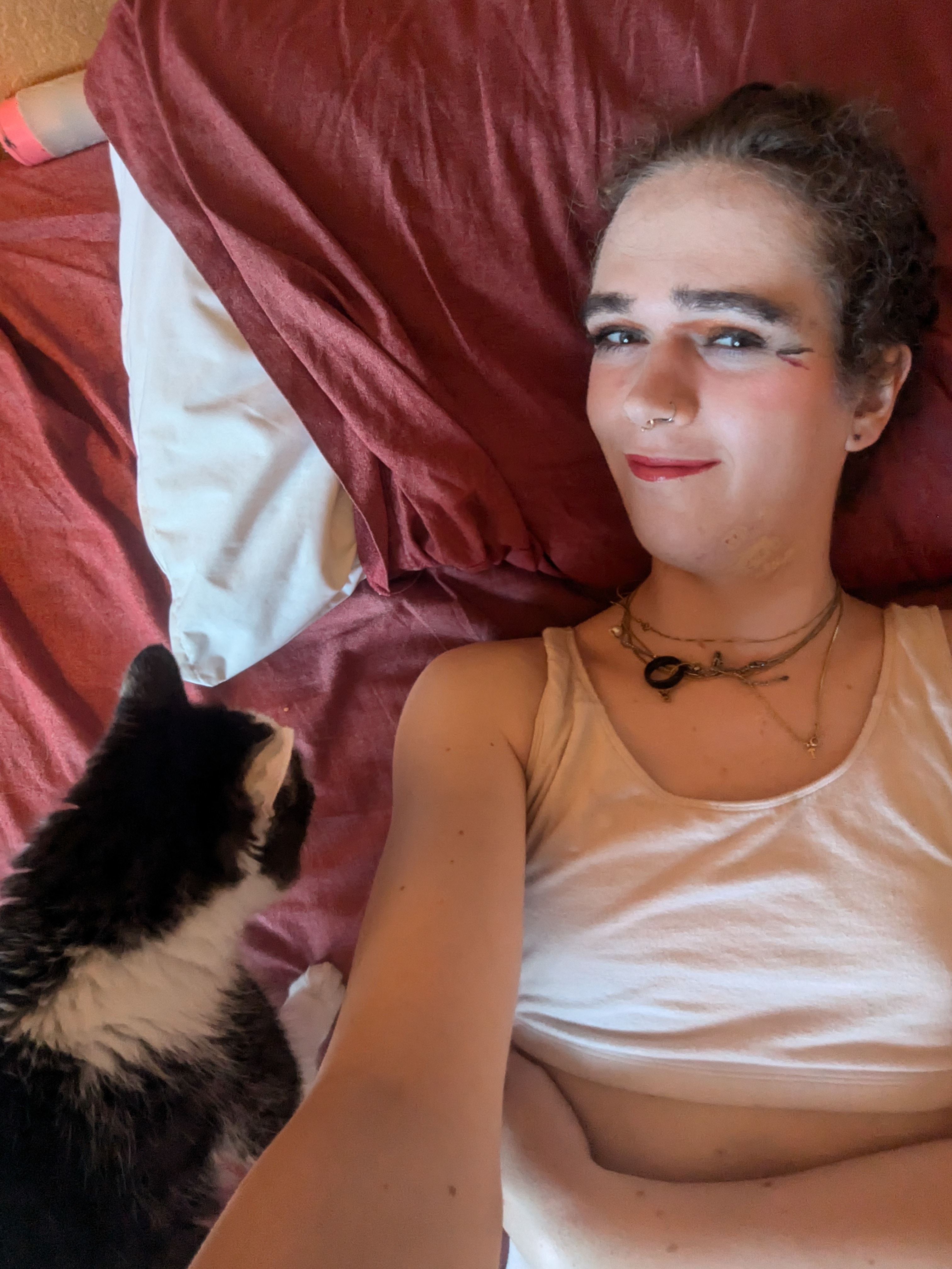 The photo shows a woman lying on a bed with a maroon blanket and a... - by Daisy