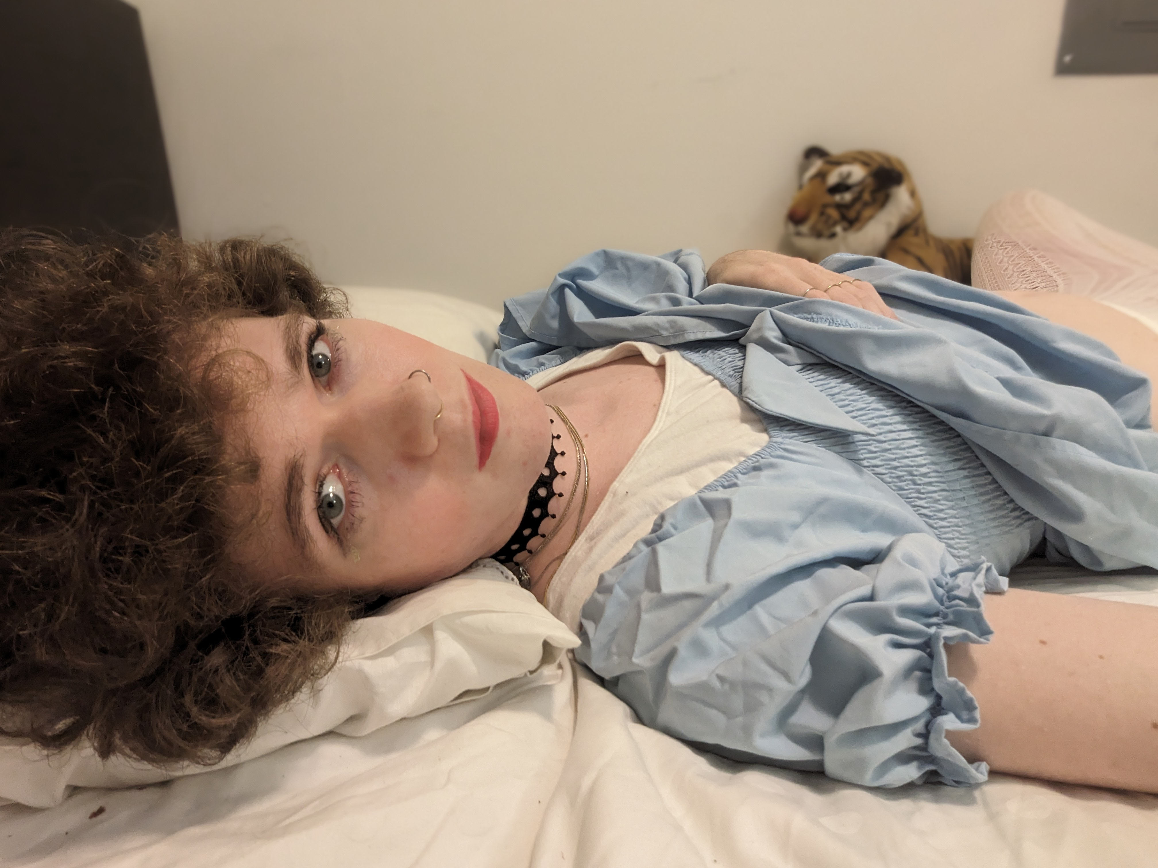 A woman laying on a bed with a red blanket. - միջոցով Daisy