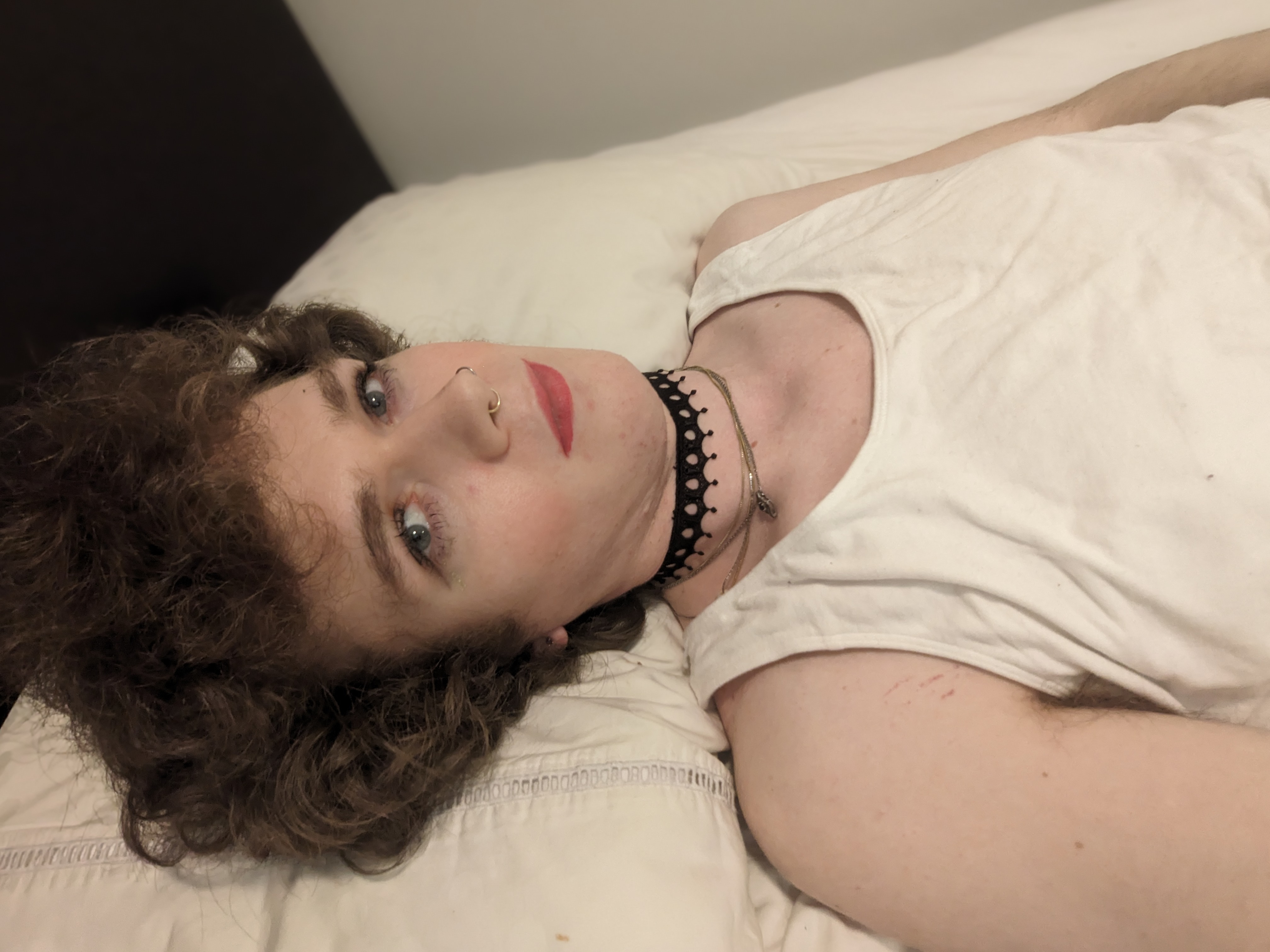 The photo shows a woman lying on a bed with light-colored sheets.... - by Daisy