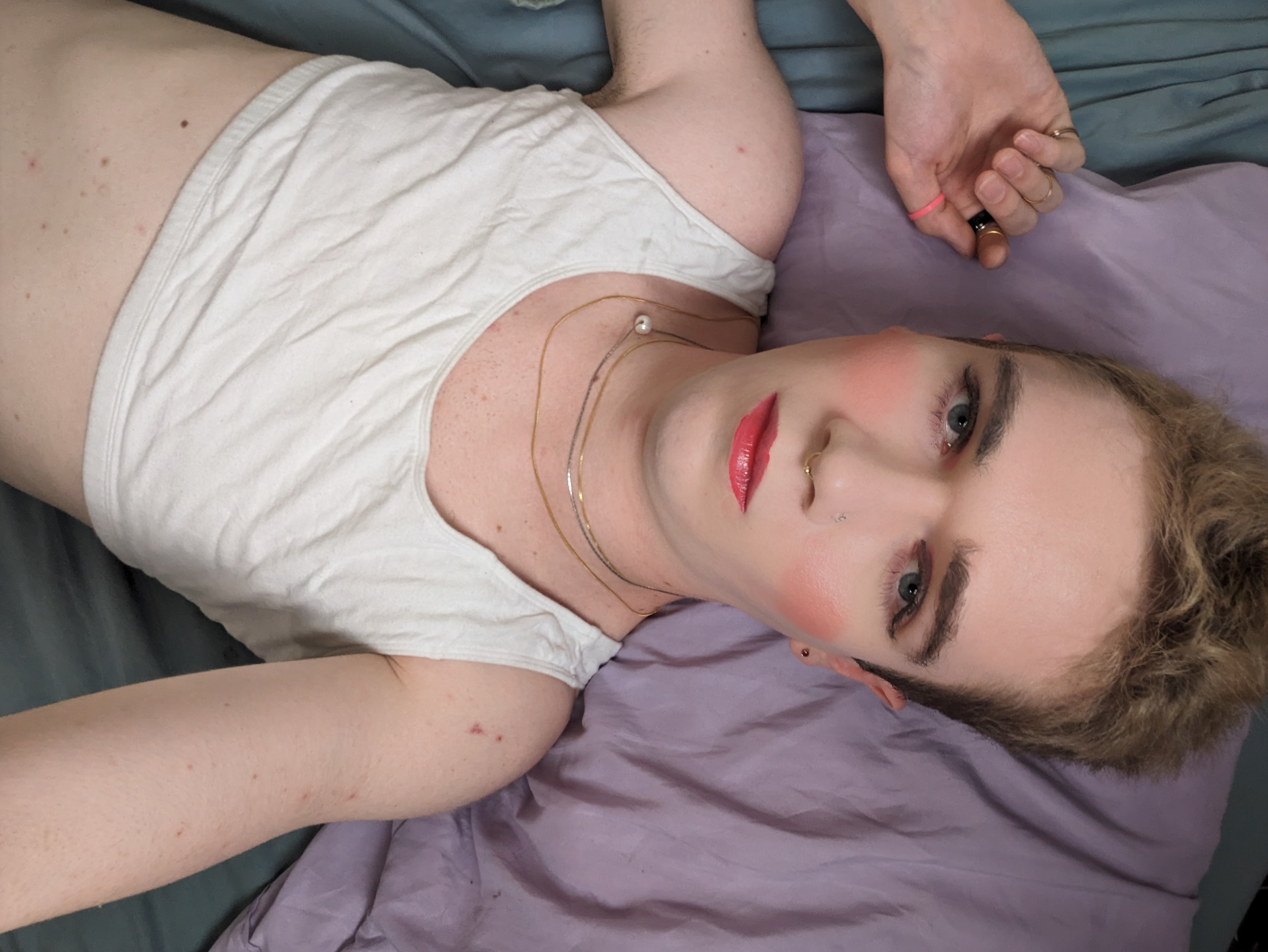 The image shows a woman lying down on a bed, resting on a pillow... - par Daisy