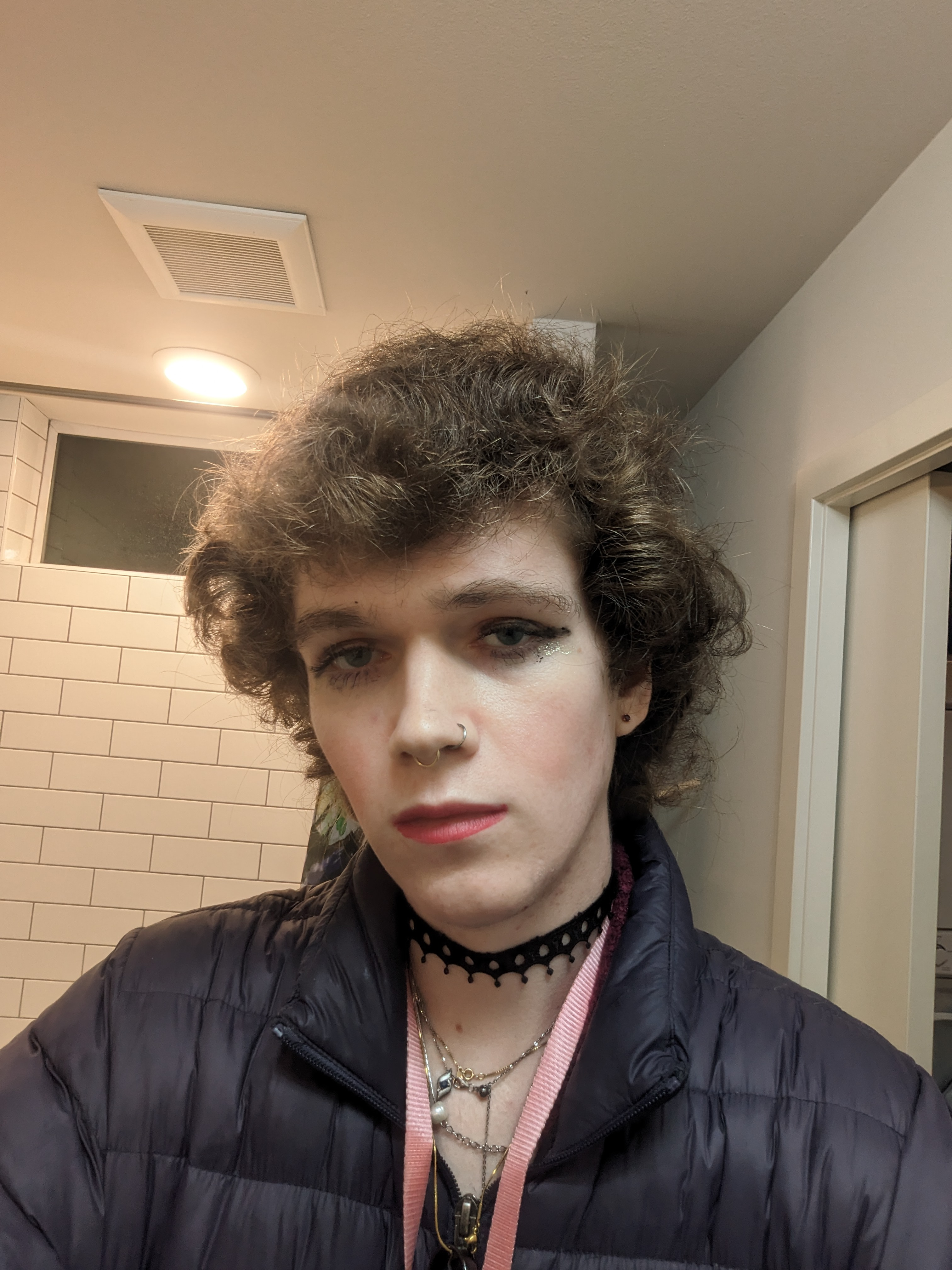The photo shows a woman with curly hair wearing makeup, including... - by Daisy