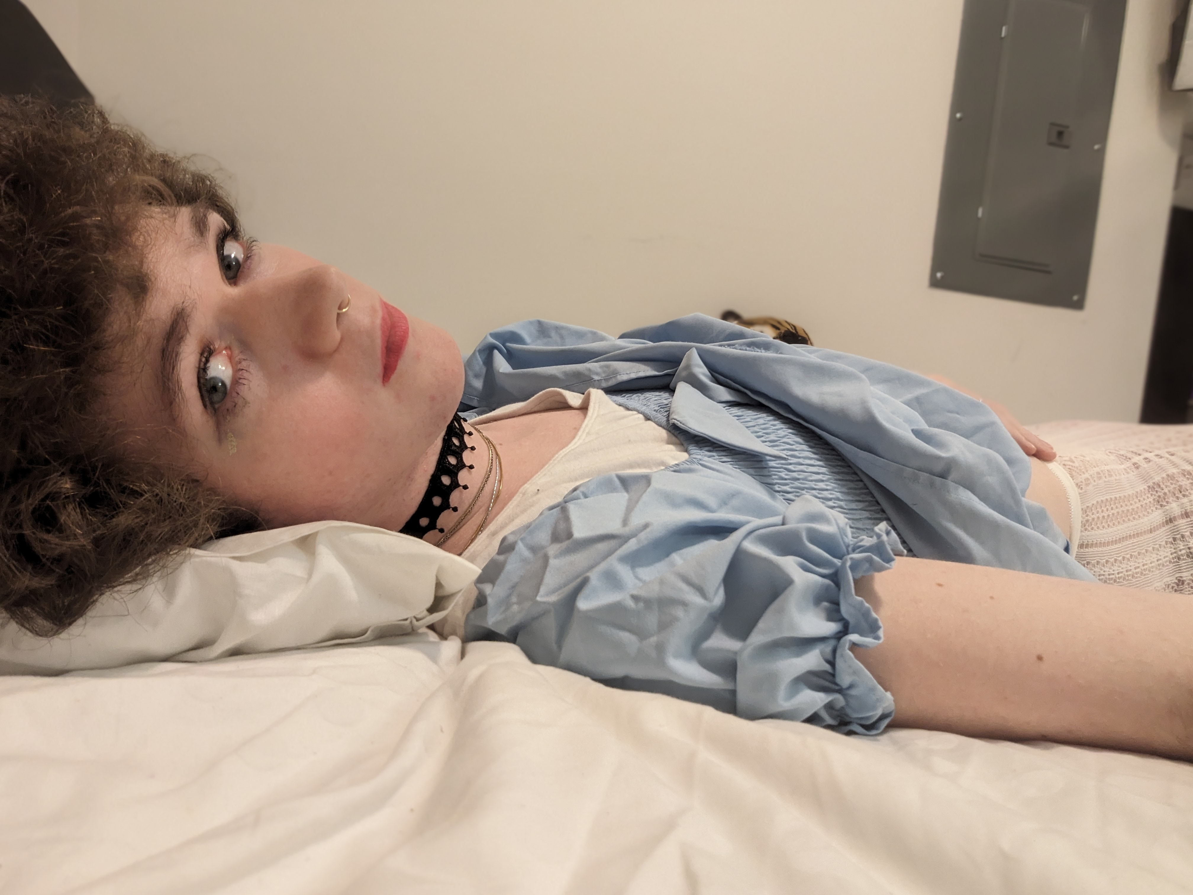 The photo shows a woman lying on a bed, resting her head on a... - by Daisy