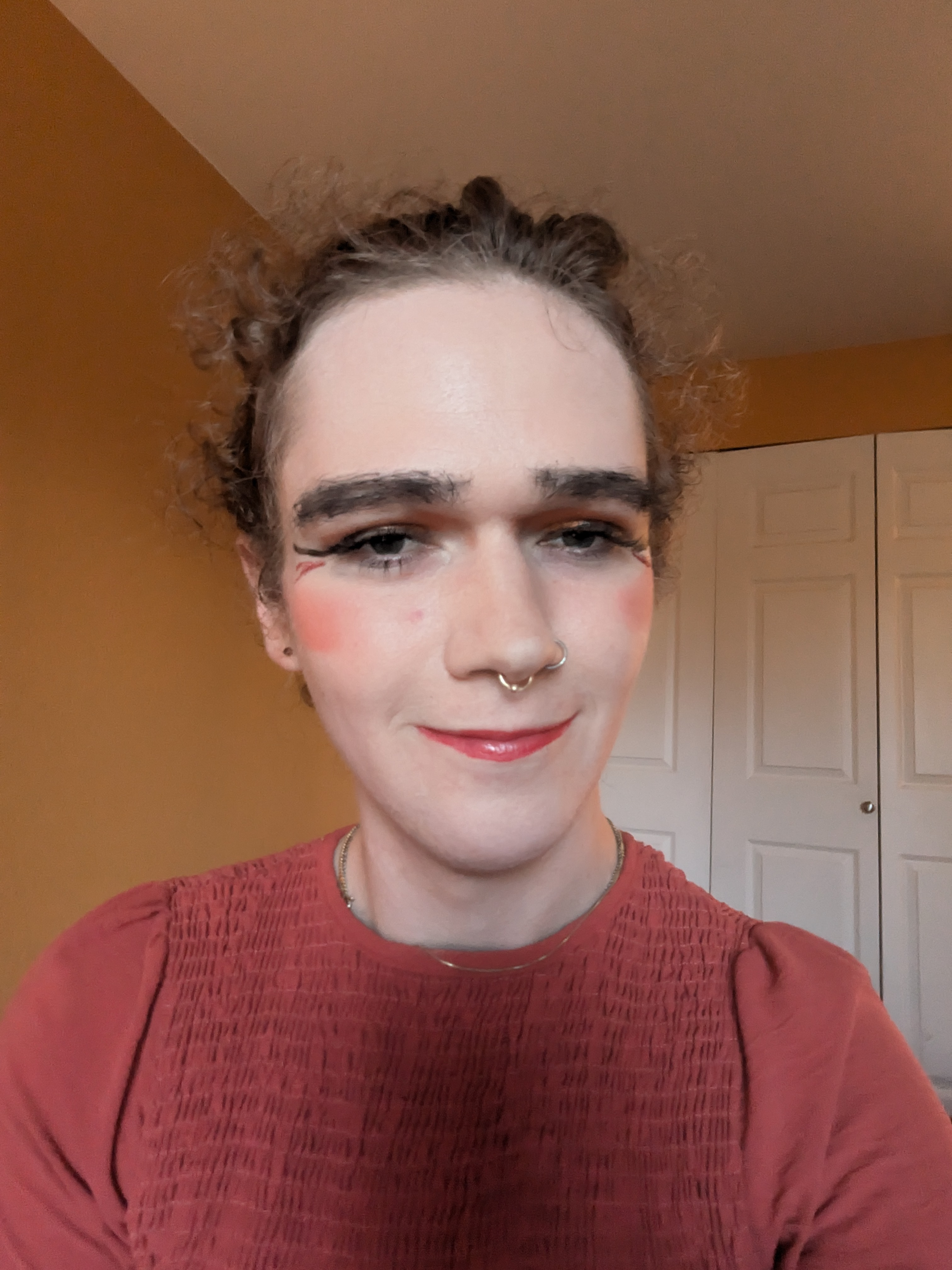 This photo shows a woman with curly hair styled back, wearing... - by Daisy