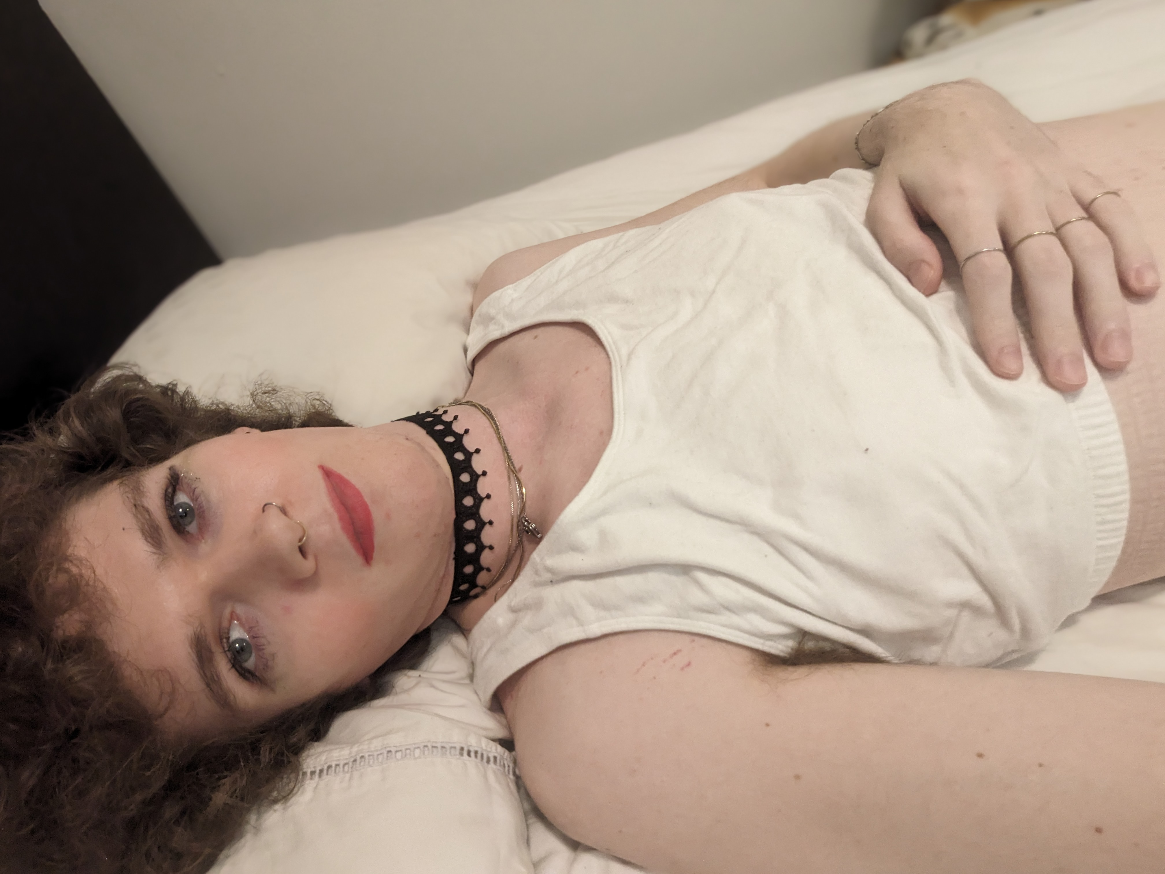 The photo shows a woman lying down on a bed with light-colored... - by Daisy