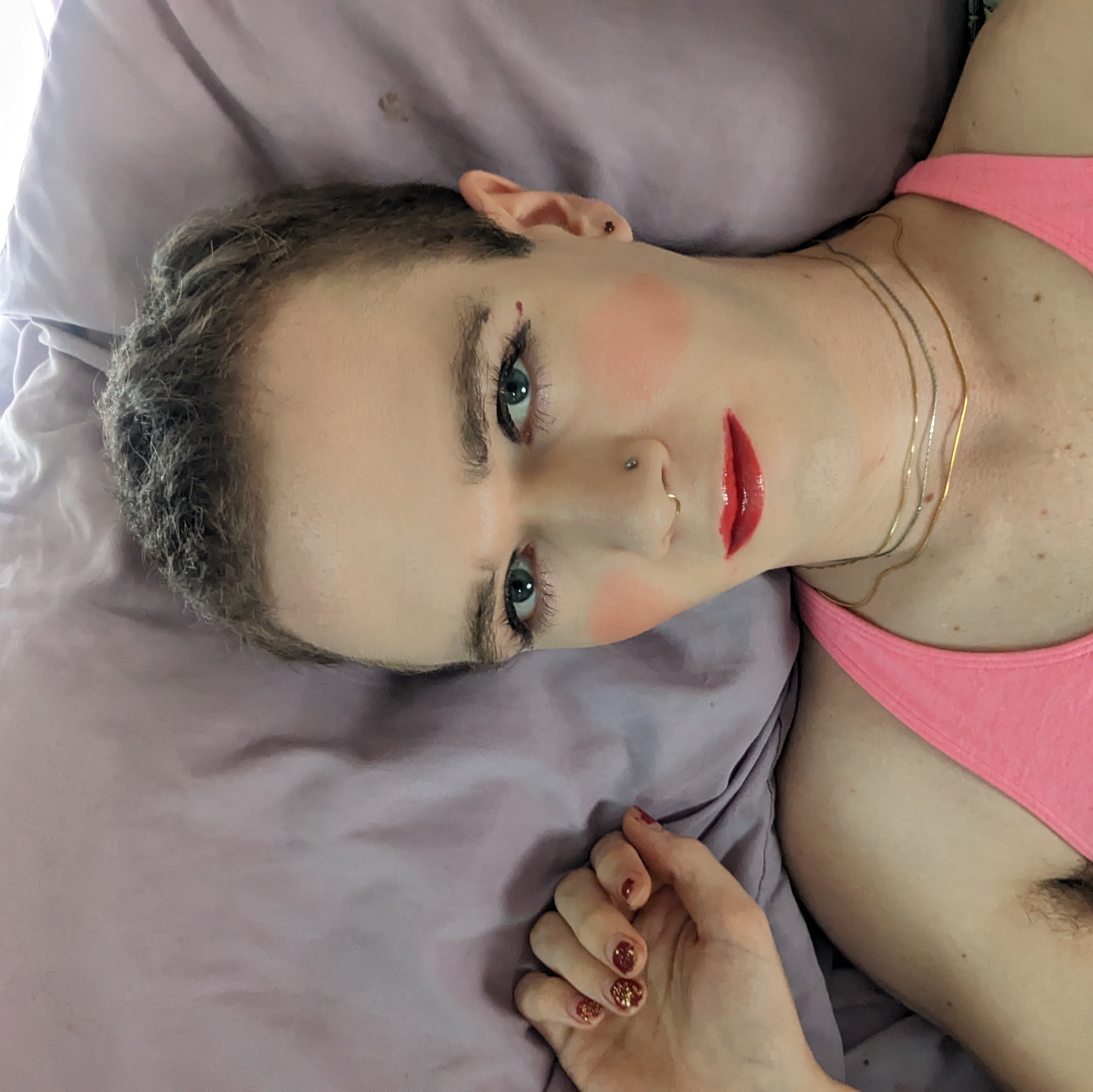 A woman laying on a bed with a red blanket. - โดย Daisy