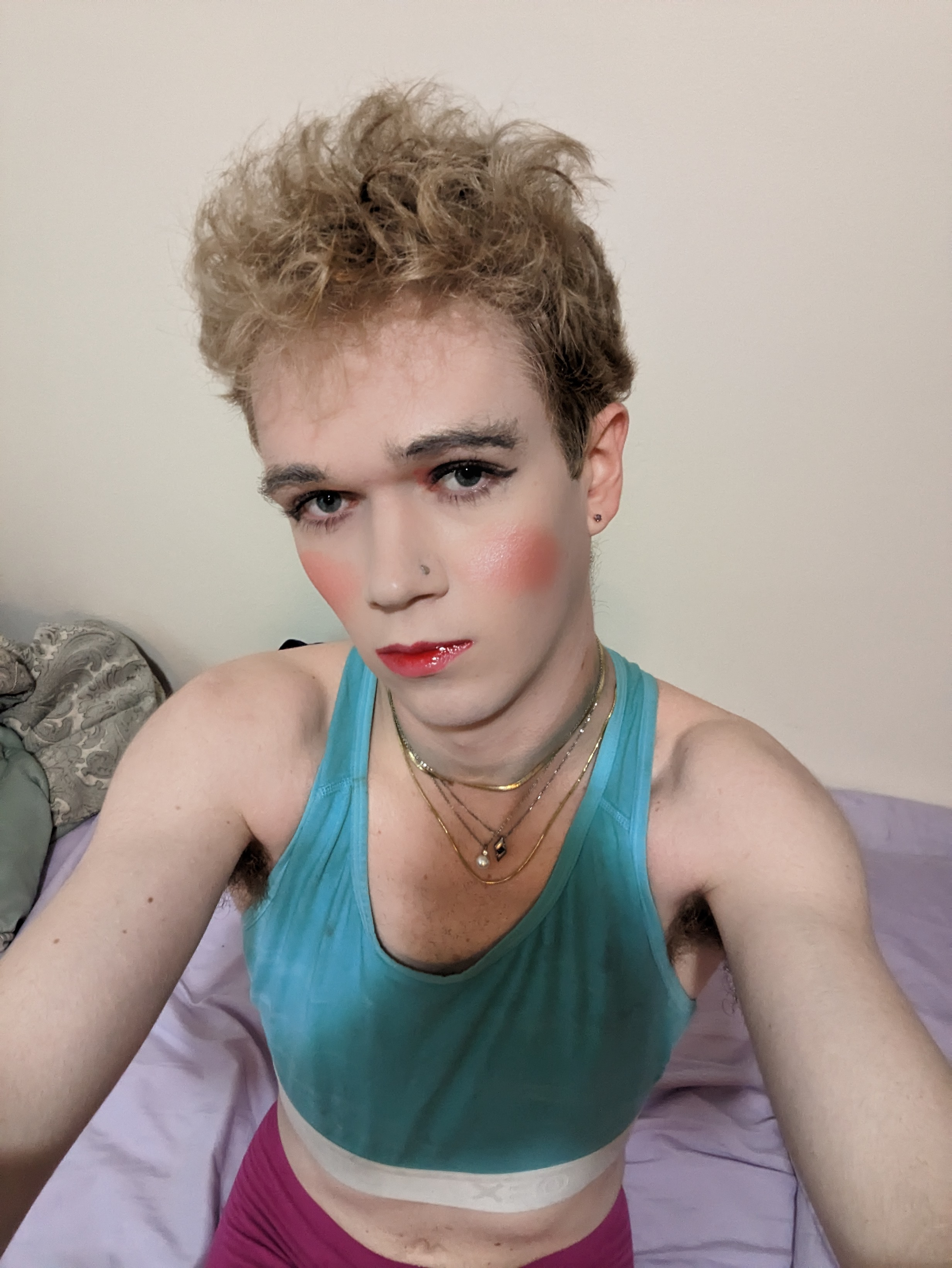 The image shows a woman with curly blonde hair wearing makeup,... - by Daisy