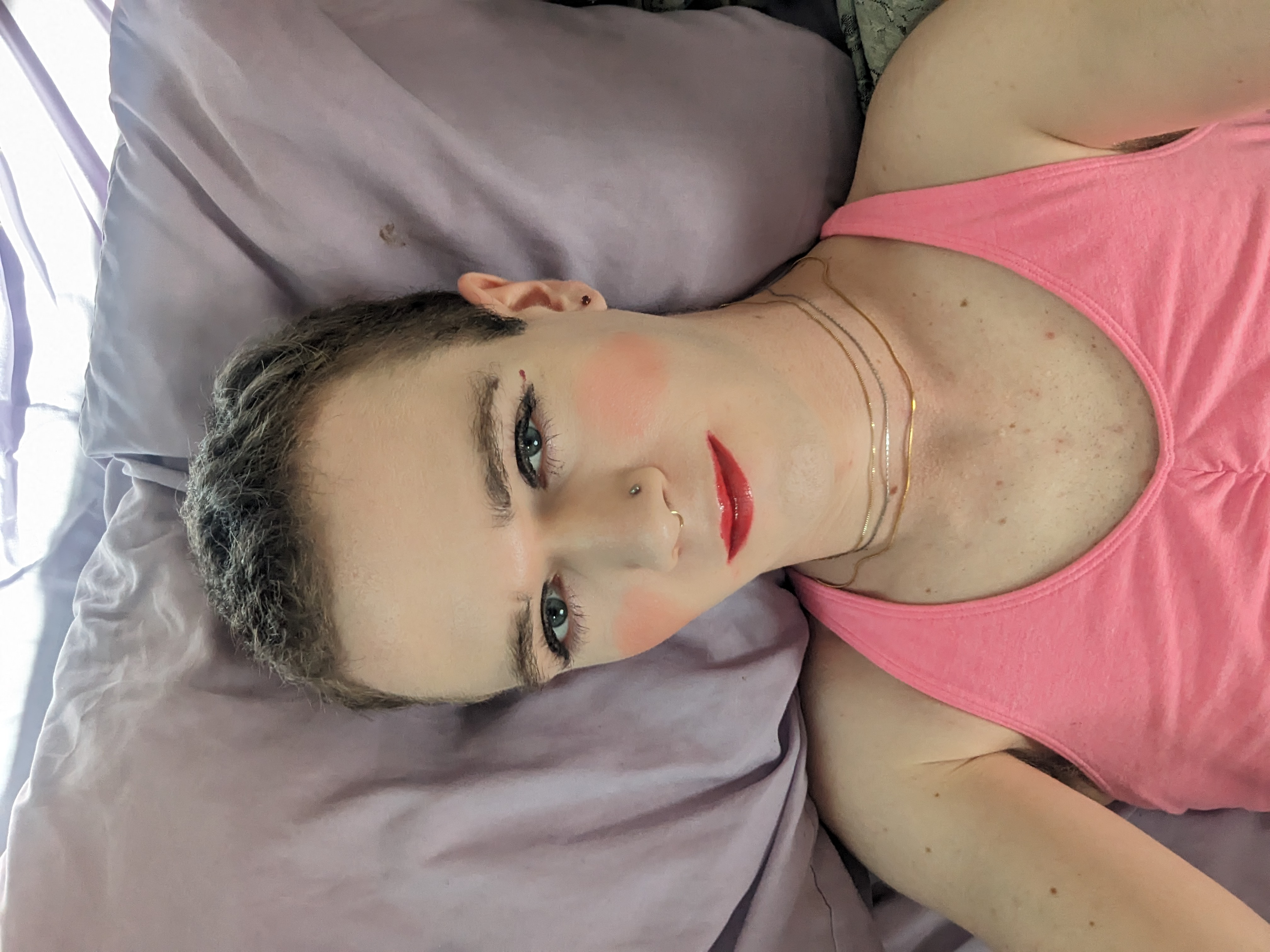 The photo shows a woman lying down on a light purple pillow or... - by Daisy