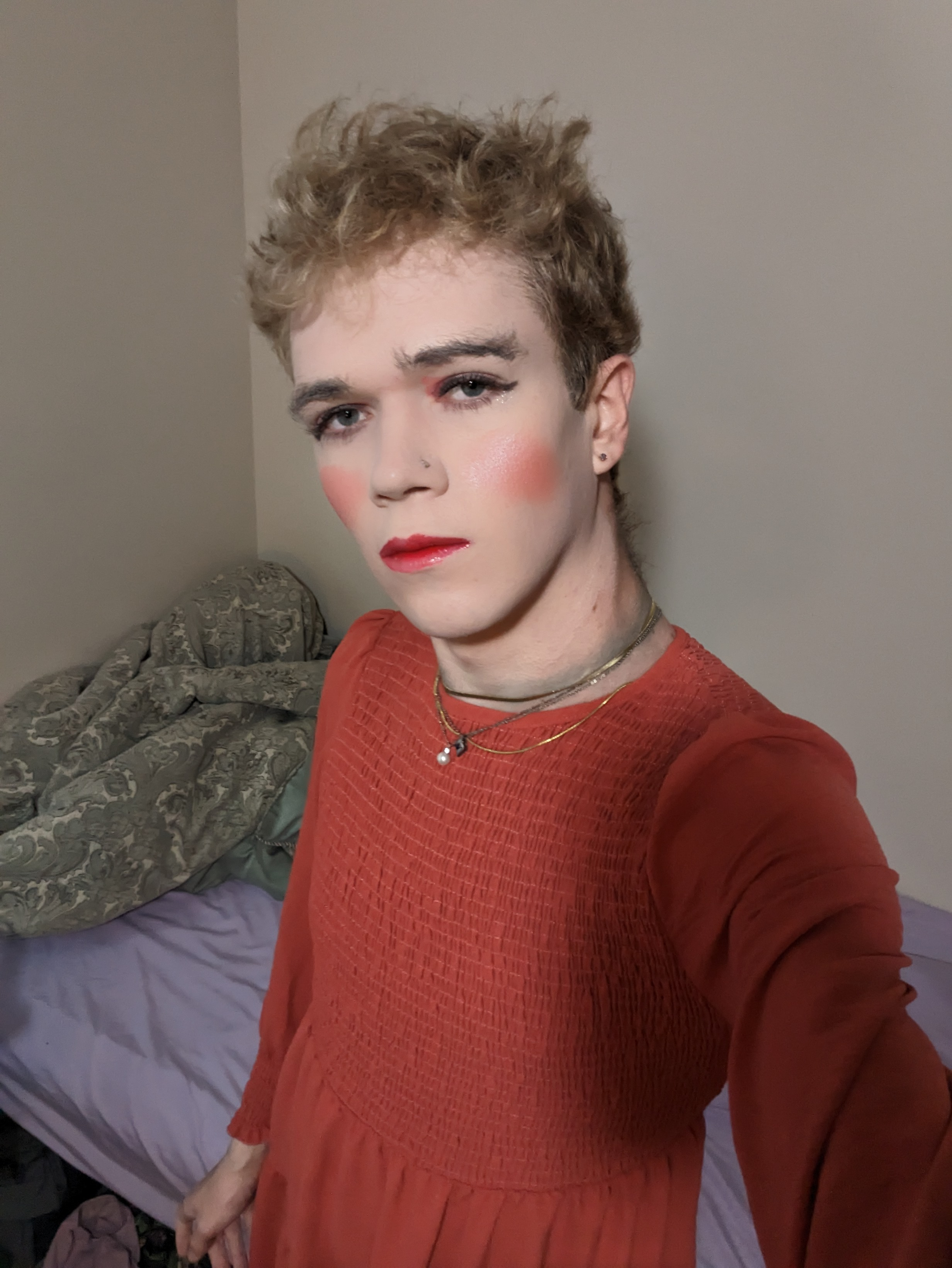 The photo shows a woman with short curly hair wearing makeup,... - by Daisy