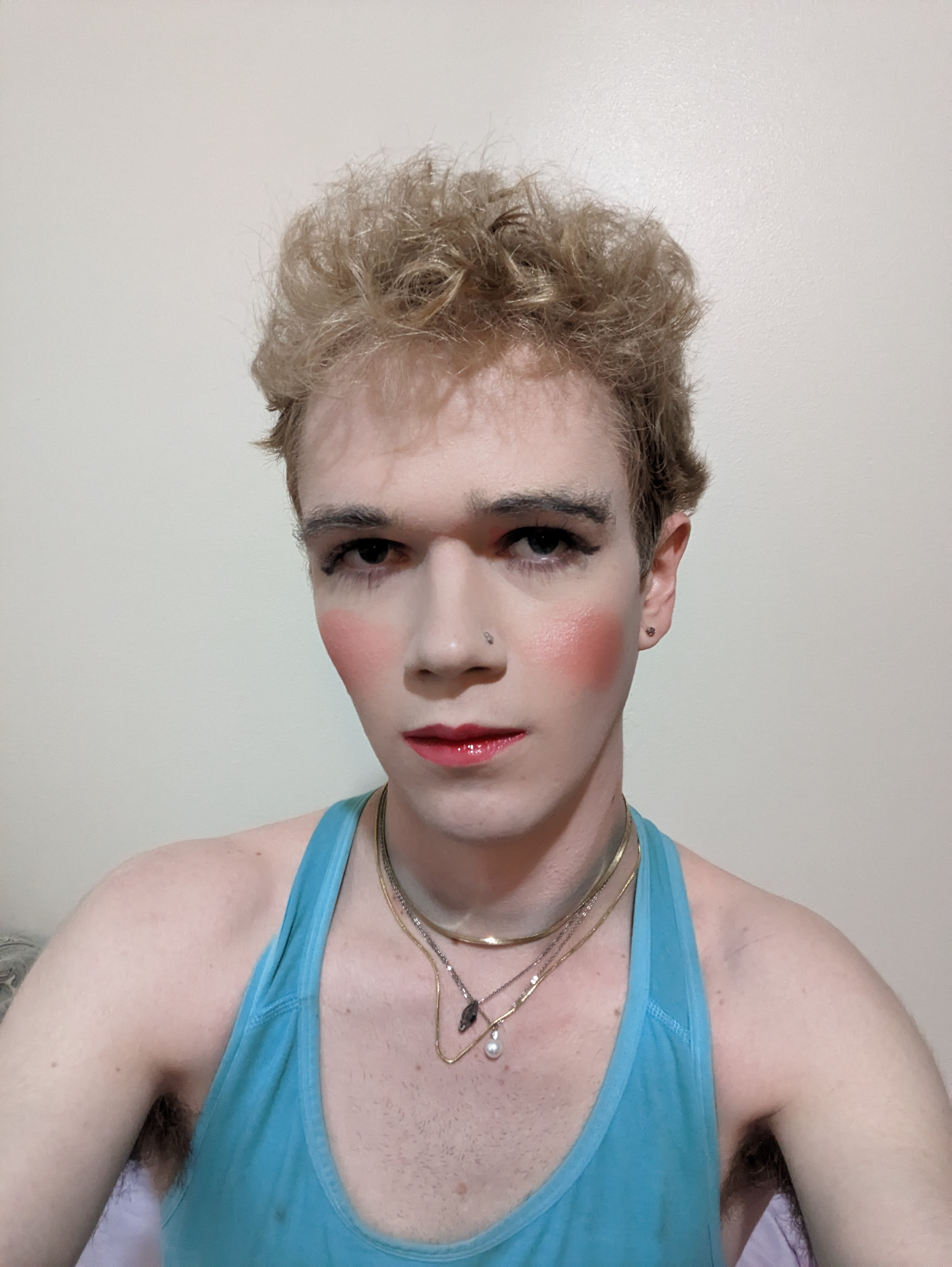 This photo shows a woman with curly blond hair wearing makeup,... - by Daisy